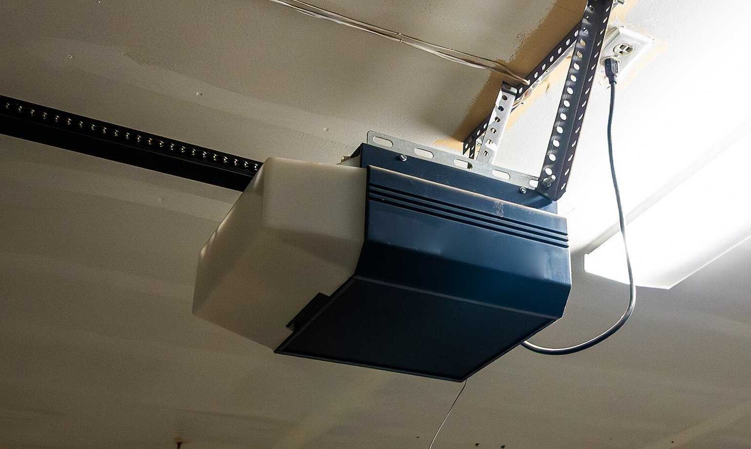 Ceiling-mounted garage door opener with its drive rail and steel mounting brackets