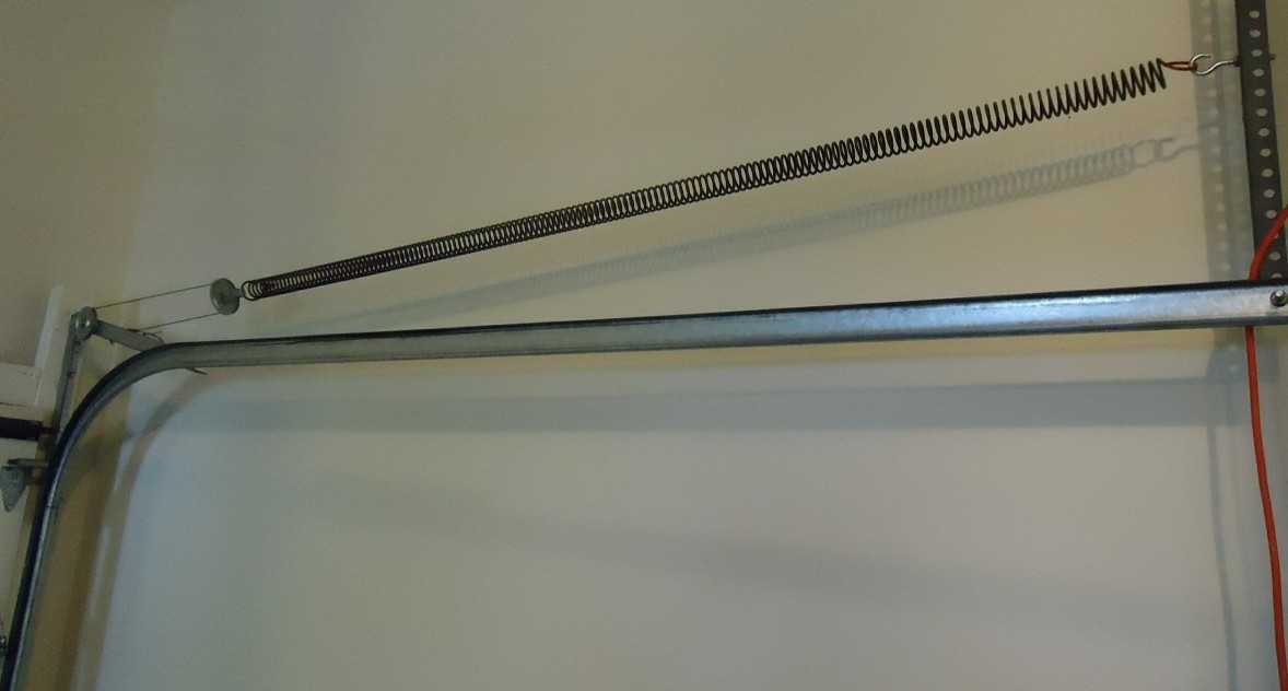 Garage door extension spring and its pulley running above the horizontal door track