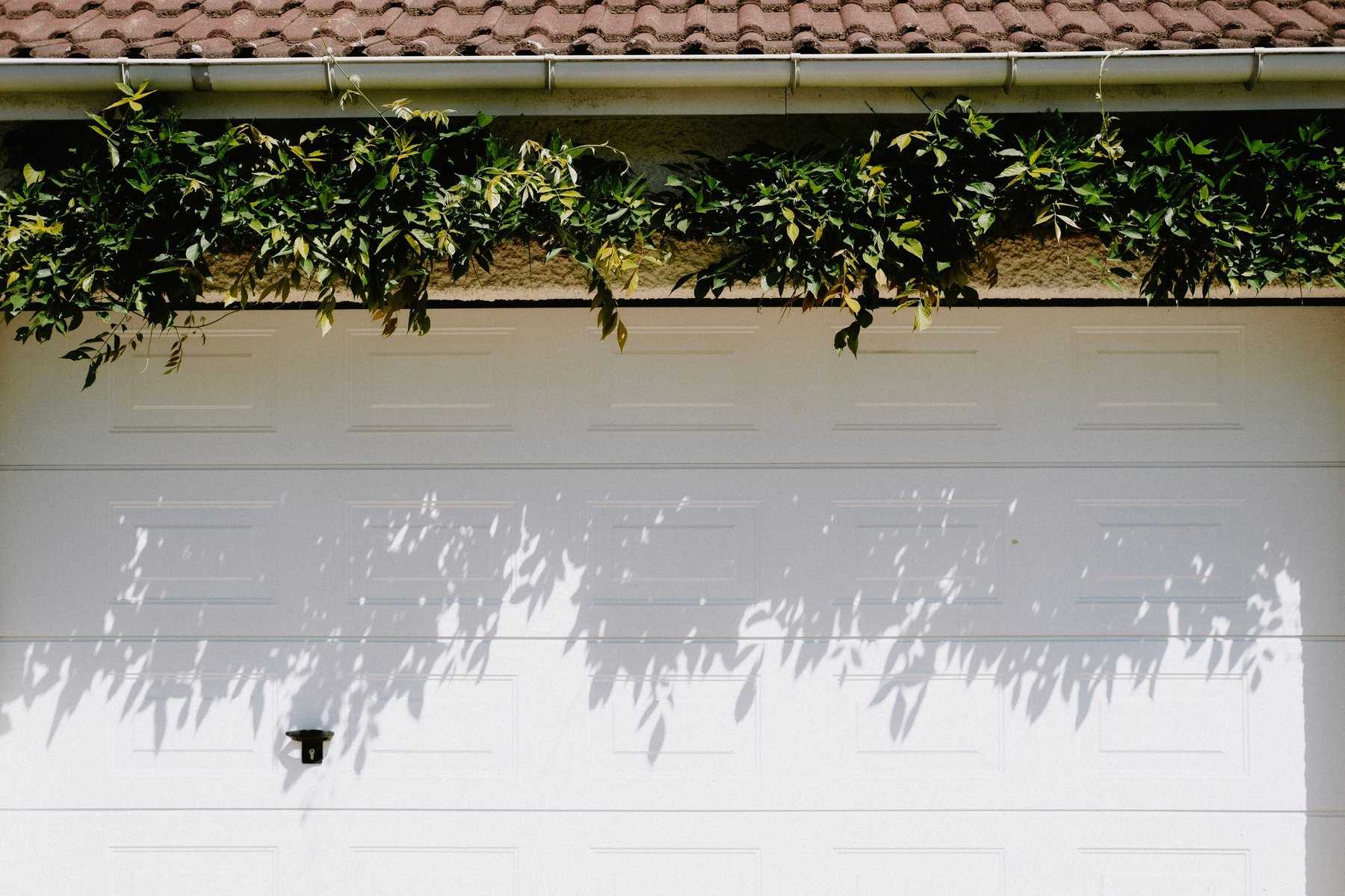 Close-up of a white steel sectional garage door with a short raised-panel pattern